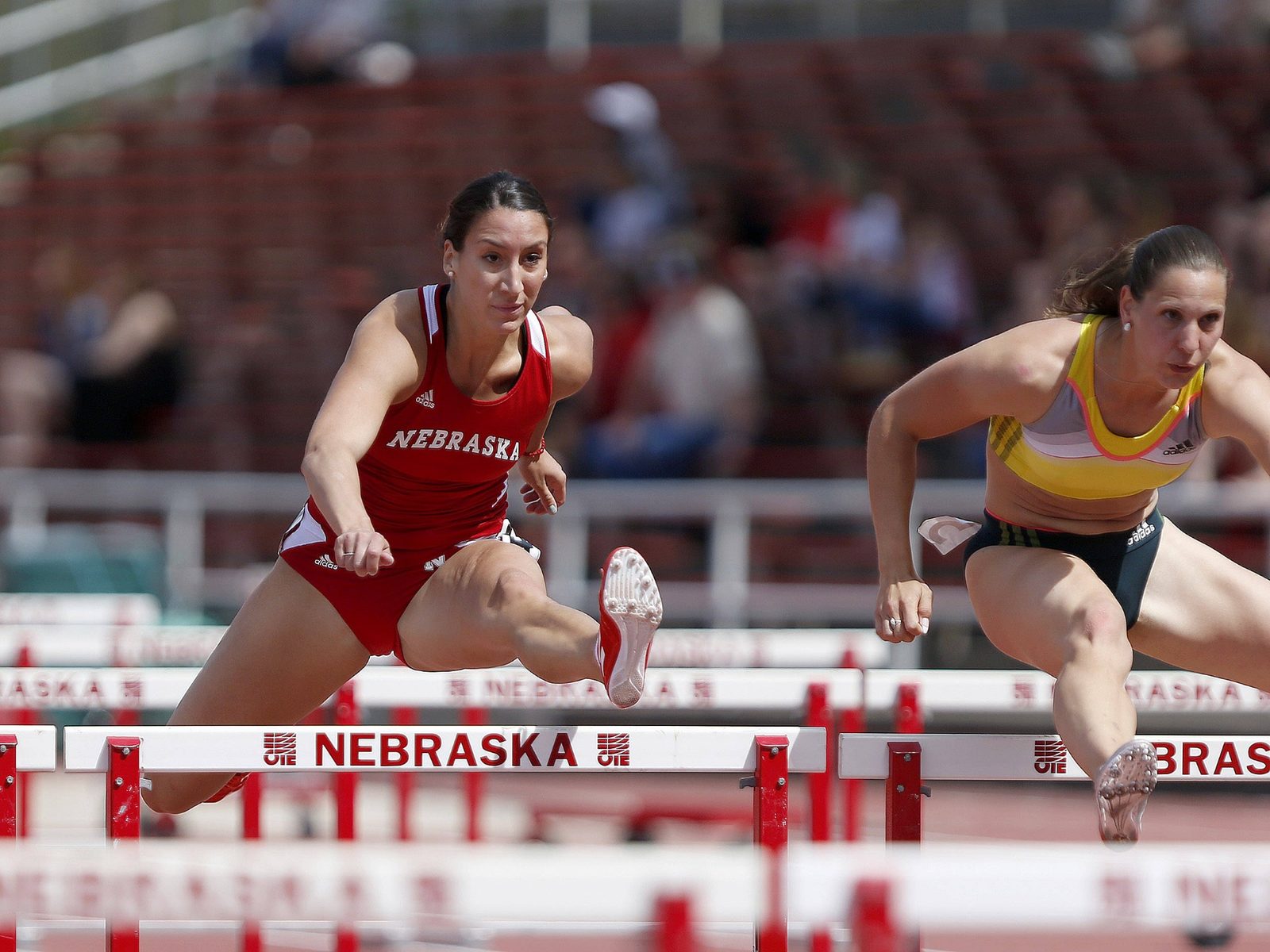 Arna Erega clearing a hurdle in competition for Nebraska